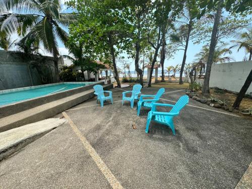 a group of blue chairs sitting next to a swimming pool at Beachfront Paradise in Tivives, Costa Rica - Your Home Away from Home in Corralillo