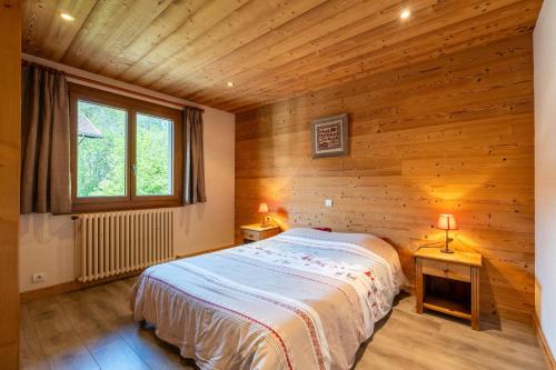une chambre avec un lit dans une cabane en bois dans l'établissement Deux Vallées 2, à La Clusaz