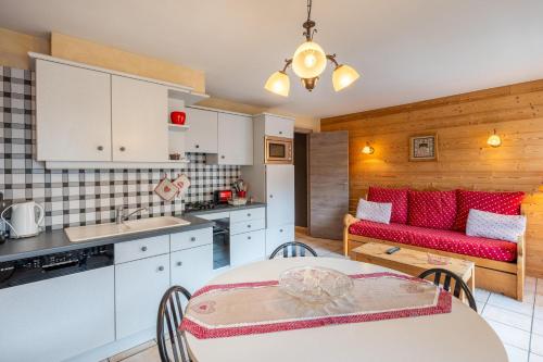 une cuisine et un salon avec une table et un canapé dans l'établissement Deux Vallées 2, à La Clusaz