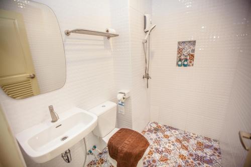 Un baño con lavabo, inodoro y espejo. en iRabbit Hotel, en Prachin Buri