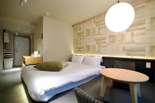 a hotel room with a bed and a table at Hotel KOTO in Sapporo