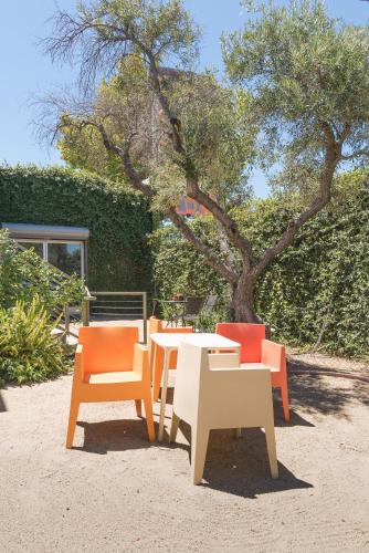 a group of tables and chairs in front of a tree at The Greens Hotel on Del Paso in Sacramento