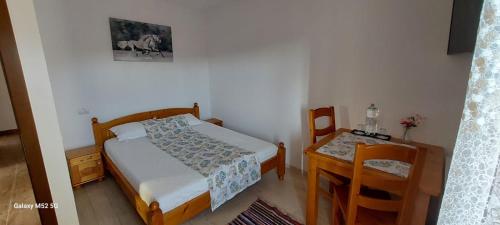 a small bedroom with a bed and a table at Craii Neamtului in Almaş