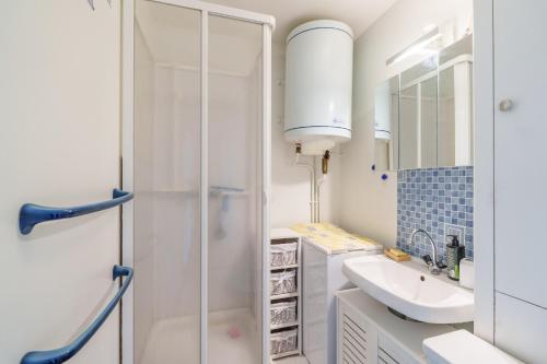 a white bathroom with a sink and a shower at Le Cocon du Chaud Costet - Avec balcon in Le Tholy