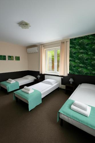 a room with three beds and a window at Hotelik SJ - bezkontaktowe zameldowanie in Łódź