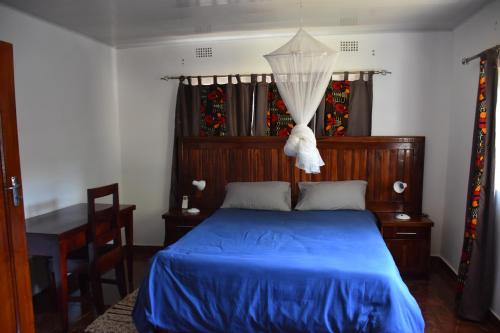 Un dormitorio con una cama con un edredón azul. en Tabonina Apartments, en Livingstone