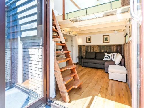 a staircase in a tiny house with a living room at Snug Holiday Home in Nieuwvliet in Nieuwvliet