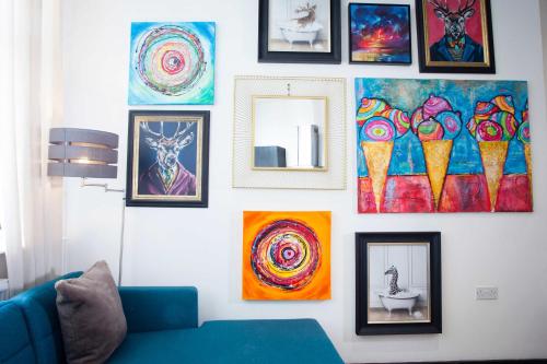 a wall with paintings and pictures on it at The Warldorf, King Size and Twin Apartment by The Hive WA1 in Warrington