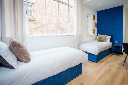 ein Schlafzimmer mit zwei Betten und einem Fenster in der Unterkunft The Warldorf, King Size and Twin Apartment by The Hive WA1 in Warrington
