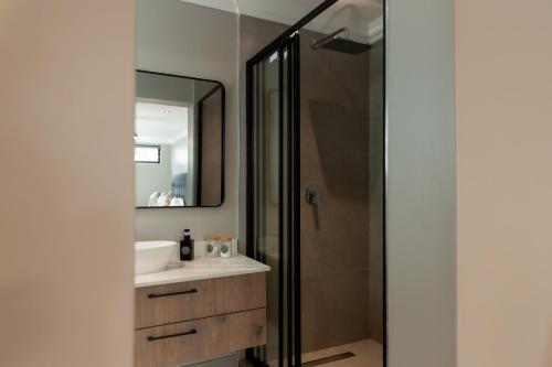 a bathroom with a sink and a mirror at Walton Cottages of Mill Park, Port Elizabeth in Port Elizabeth
