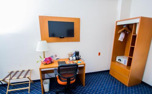 a room with a desk with a chair and a tv at Sleep Inn Monclova in Monclova