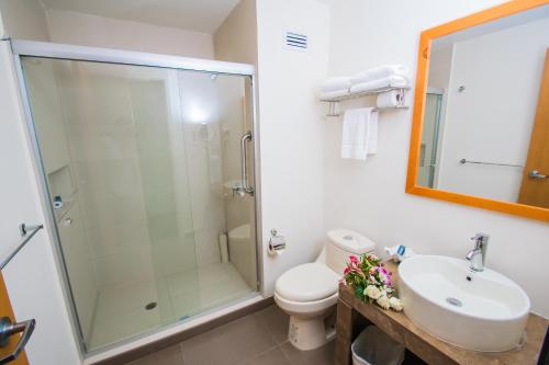 ein Bad mit einer Dusche, einem Waschbecken und einem WC in der Unterkunft Sleep Inn Monclova in Monclova