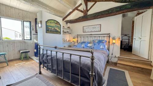 una camera da letto con un letto con cuscini blu di Charmante villa au centre de la Couarde avec cour a La Couarde-sur-Mer