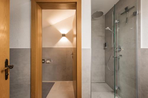 a bathroom with a shower and a glass door at Pension Bergwelt in Neustift im Stubaital