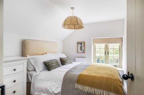 ein weißes Schlafzimmer mit einem Bett und einem Fenster in der Unterkunft Pelsham Farm Cottage in Peasmarsh