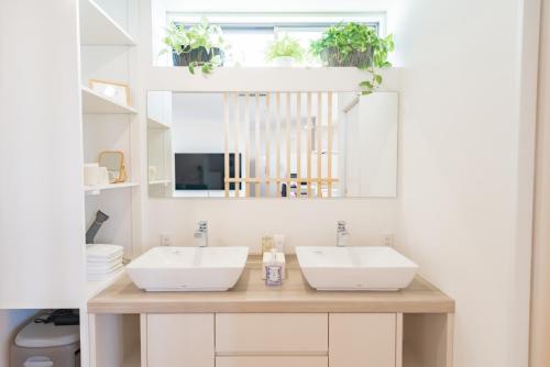 a bathroom with two sinks and a mirror at Locanda katsuren 勝連荘 in Miyako Island