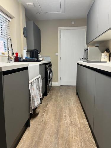 a kitchen with black and white counter tops and a sink at Luxury Guest Suite Dog Friendly in North Scarle