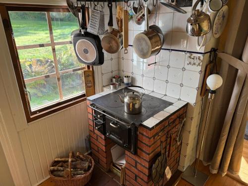a small kitchen with a stove and some pots and pans at Smedens Hus in Svarvaremåla