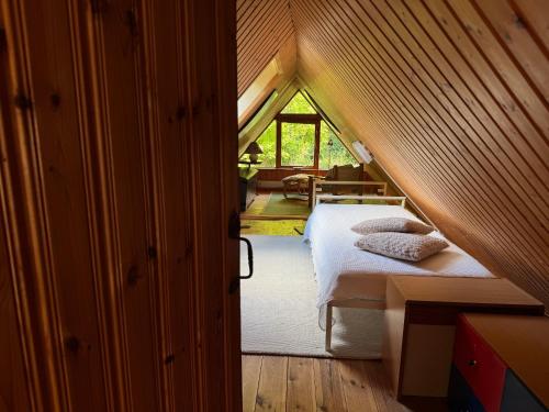 a attic bedroom with a bed in a room at Smedens Hus in Svarvaremåla