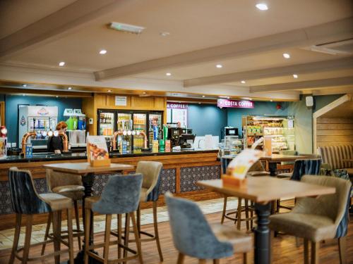 a restaurant with tables and chairs and a counter at Coastfields Holiday Village in Ingoldmells