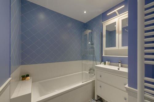 a bathroom with a tub and a sink at Le Clos Bleu du Lac - Charmante location tout proche du lac d'Annecy avec jardin in Saint-Jorioz