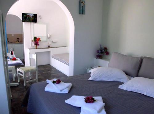 a bedroom with a bed with towels on it at Aegean Village in Parikia