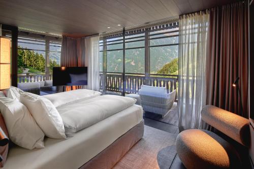 a bedroom with a large white couch and a balcony at AMONTI Chalets in Molini di Tures