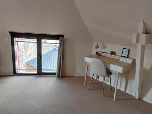 een kamer met een bureau, een stoel en een raam bij Le Rubis - hyper centre et proche plage in Dinard