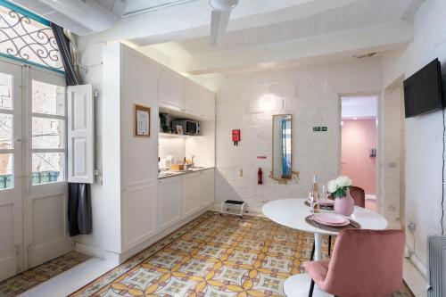 a living room with a table and a kitchen at Valletta Letcom Studio in Valletta