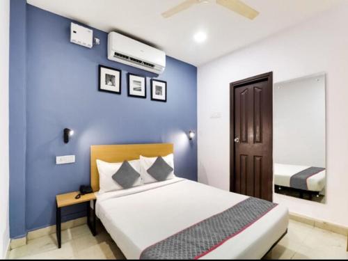 a bedroom with a blue wall and a bed at Townhouse Golkonda Fort Formerly Hotel Langar Houz in Haidar Sāhibgūda