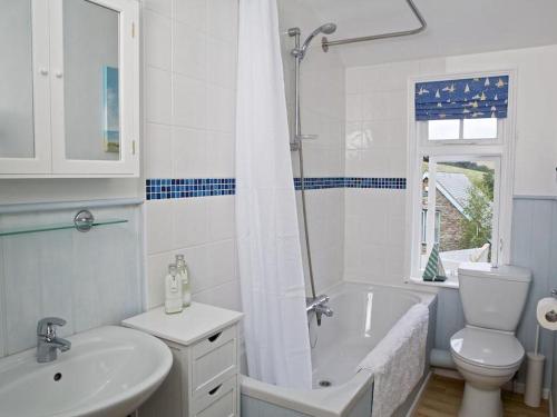 Un baño con lavabo, bañera e inodoro. en St Leonards, en Salcombe