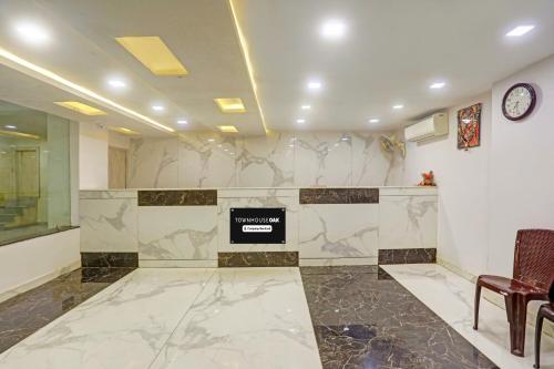 a lobby with a waiting room with a clock on the wall at Townhouse Oak City Centre Dhanbad Formerly Hotel Kuber Inn in Dhanbād