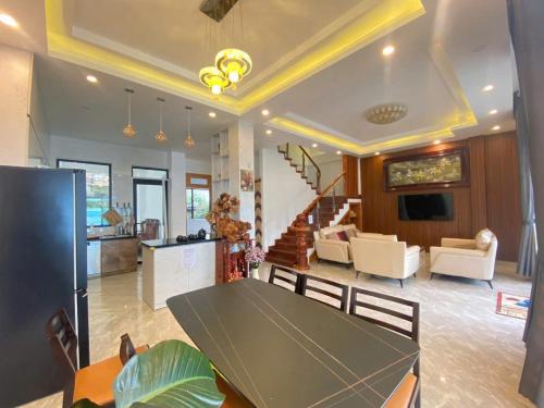 a dining room and living room with a table at AnAn VILLA in Khu Chi Lăng