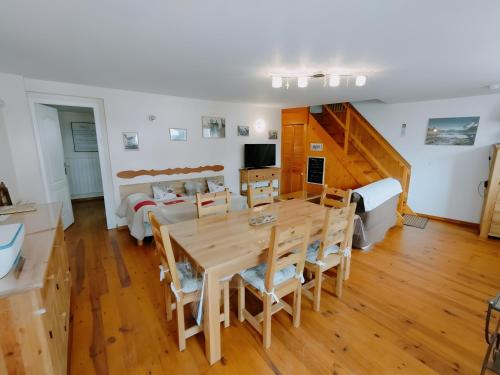 a dining room and living room with a table and chairs at Gite Notre Désir in Abriès
