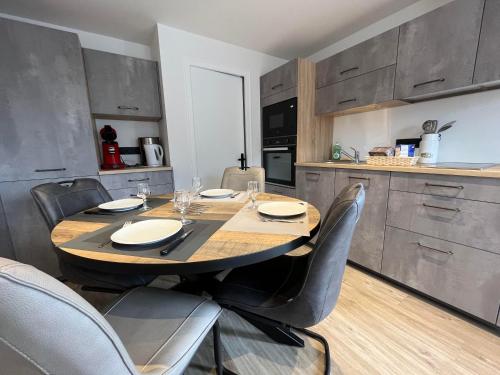 una cucina con un tavolo e sedie in legno in una cucina di Fenil a La Clusaz