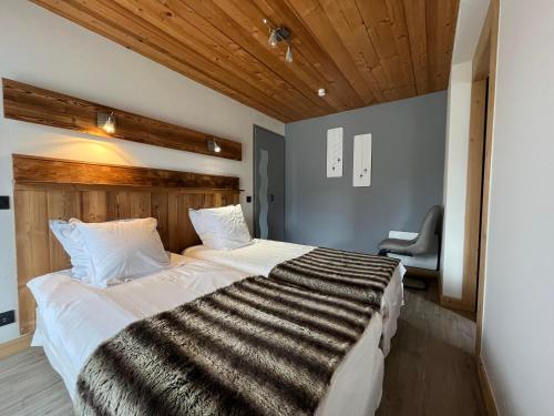 una camera da letto con un letto grande con testiera in legno di Fenil a La Clusaz
