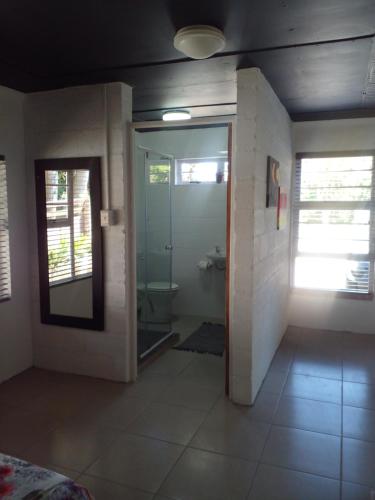 a bathroom with a toilet and a glass door at Dollery House in Port Alfred