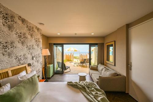 une chambre avec un lit et un canapé ainsi qu'un salon dans l'établissement Beachhouse Hotel, à Zandvoort