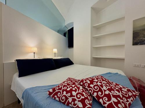 a bedroom with a bed with red and white pillows at The vault of the village, 200 meters from the center and the lake in Lovere