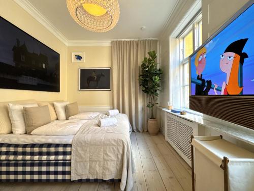a bedroom with a bed and a flat screen tv at Luxury 260 sqm with 4BR overlooking Kings Garden in Copenhagen