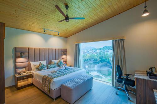 Un dormitorio con una cama y una ventana grande. en Bamboo Saa Resort & Spa - Udaipur, en Udaipur