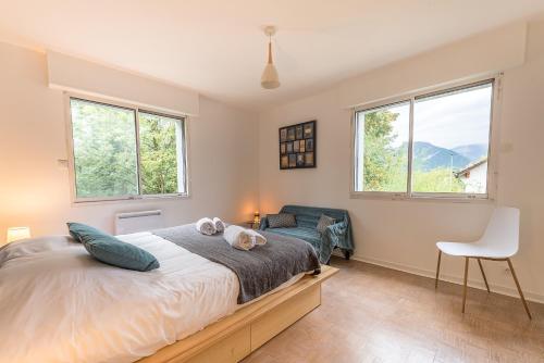 Un dormitorio con una cama y una silla y ventanas. en Le Nova du Laudon - Centre Saint-Jorioz et proche plage, en Saint-Jorioz