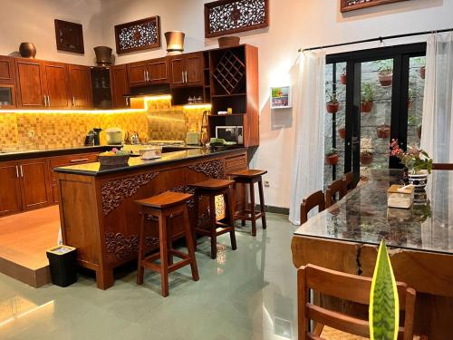 a kitchen with a large island with bar stools at Ndalem Srigading Villa Solo Entire Villa in Bonorejo