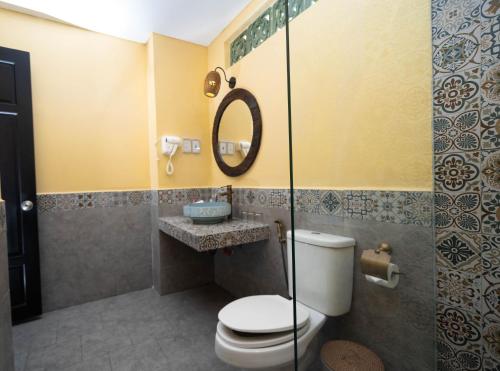 a bathroom with a toilet and a sink and a mirror at Nature Villa Hoi An By K D H in An Bang