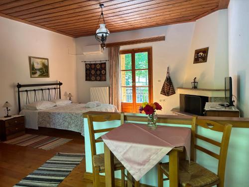 a dining room with a table and a bed at Andrea Sofi Guesthouse in Dhimitsana