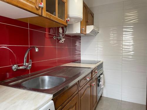 a kitchen with a sink and a red wall at Maryland Terrace by RPG Properties in Albufeira