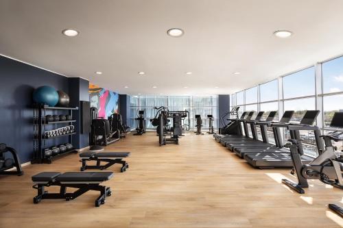 a gym with treadmills and cardio equipment in a building at Sheraton Milan Malpensa Airport Hotel & Conference Centre in Ferno