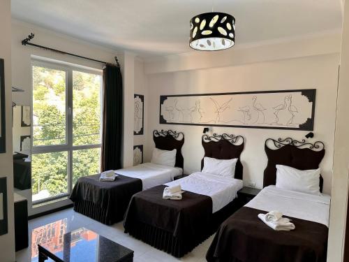 Una habitación de hotel con dos camas y una ventana. en The one family boutique, en Tiflis