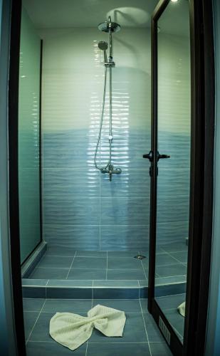 a bathroom with a shower with a towel on the floor at Impuls hotel in Vidin