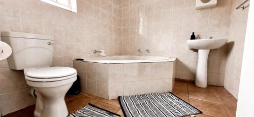ein Badezimmer mit Badewanne, Toilette und Waschbecken in der Unterkunft 3 Bedroom Apartment in Roodepoort